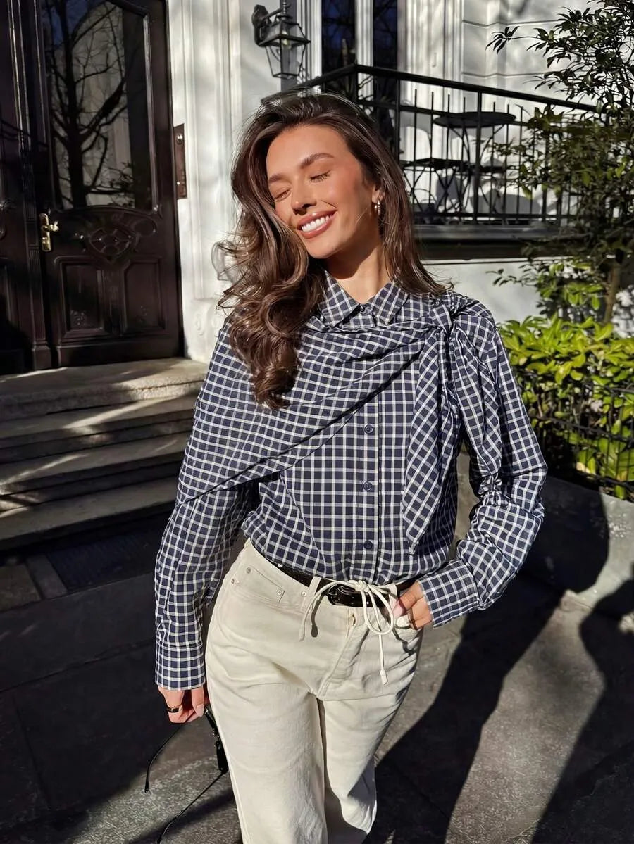Navy plaid scarf-tie shirt styled with cream trousers